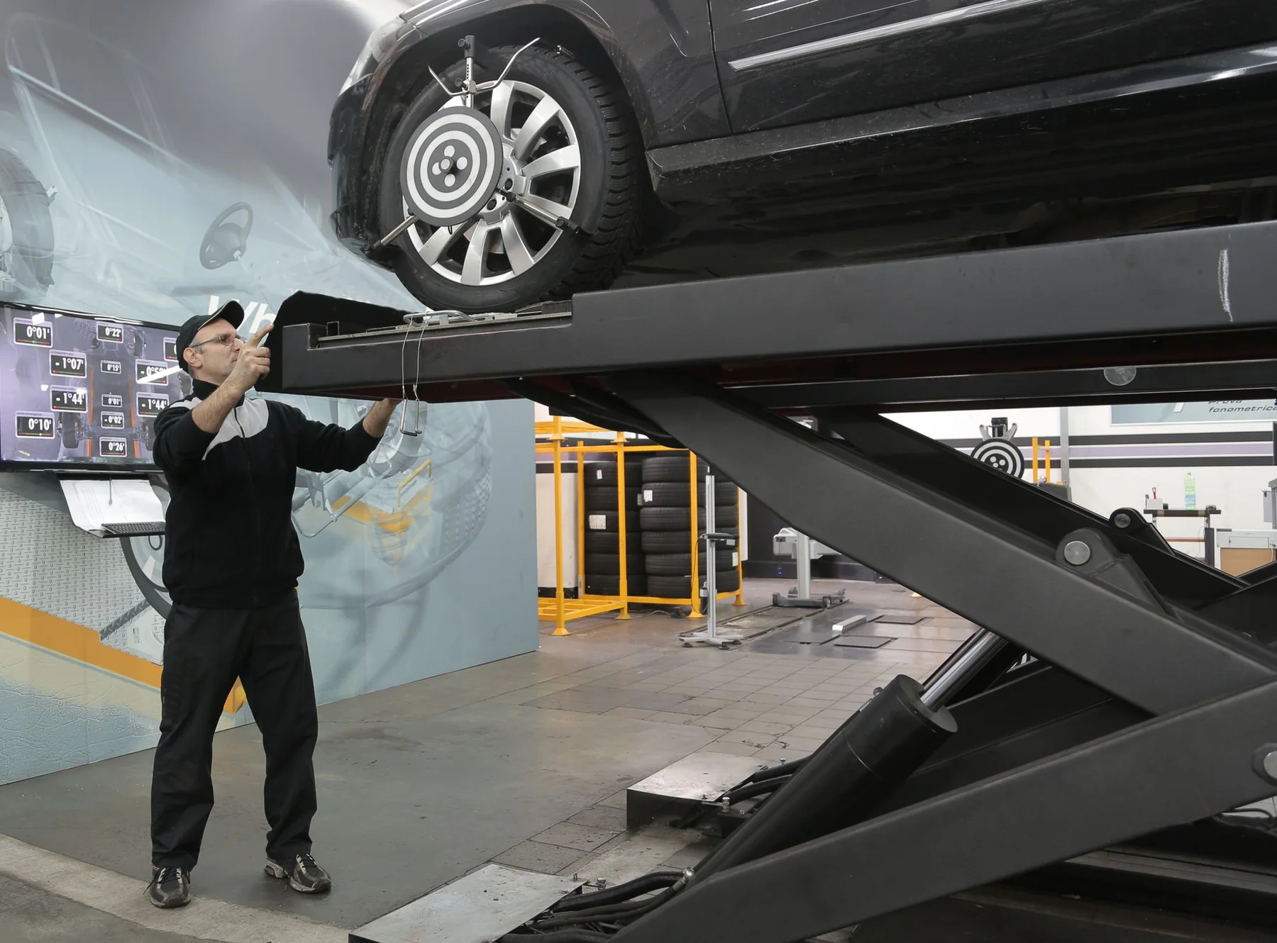 Mechaniker prüft ein angehobenes Fahrzeug, illustrativ
